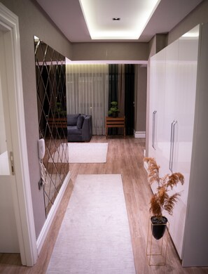 A modern interior with a sofa, a small table with a plant, and a wardrobe.