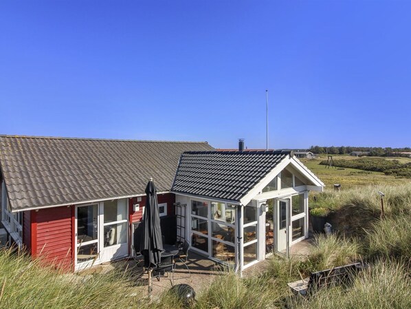 A red building with a glass enclosure and a black roof.