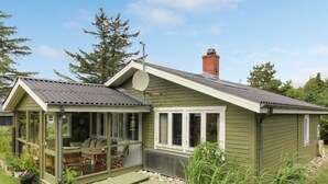 A house with a covered patio, a chimney, and a small shed.