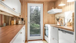 Une cuisine moderne avec des meubles en bois, un four encastré et un lave-vaisselle.