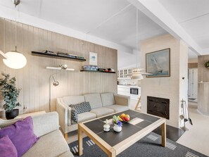 Un salon moderne avec un canapé, une table basse et une cheminée.
