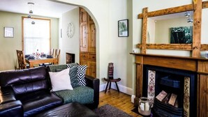 A living room with a fireplace, a dining area, and a wooden cabinet.