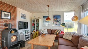 Un salon chaleureux avec une cheminée, un canapé, une table en bois et une bibliothèque.