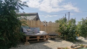 A wooden deck with a bed, a small table, and a decorative birdcage. - Suite Noelie, son Ecran de Cinema et sa Baignoire d Époque (Brassac)