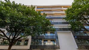 Un edificio de varios pisos con un diseño arquitectónico moderno, que cuenta con balcones y ventanas amplias.