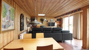A wooden interior with a dining area, sofa, TV, and kitchen. - "Ehmi" - 500m from the sea by Interhome (Løkken)