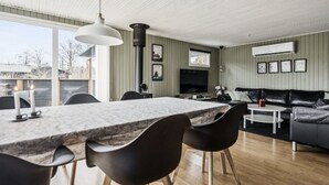 Ein modernes Wohnzimmer mit Essbereich, einer Couch und einem Fernseher.