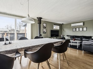 Un espacio moderno para vivir con comedor, sofá y televisor.