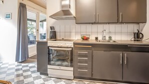 A modern kitchen with a Voss oven, stainless steel cabinets, and a checkered floor.