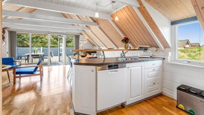 Een moderne keuken met witte kasten, een centraal eiland en een groot raam.