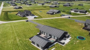 Oversigtsbillede af et boligområde med flere huse, alle med et moderne design, plane tage og store vinduer.