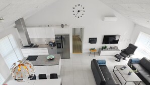 En moderne, åben stue med et køkken, spiseområde og siddepladser.