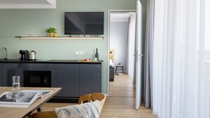 Eine moderne Küche mit Flachbildfernseher, Mikrowelle und Kaffeemaschine.