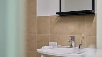 A bathroom with a white sink, a mirror, and a towel rack.