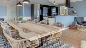 A modern kitchen with a central island, built-in appliances, and pendant lighting.