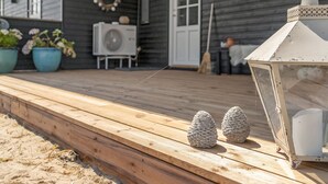 A wooden deck with a lantern and two pinecones.