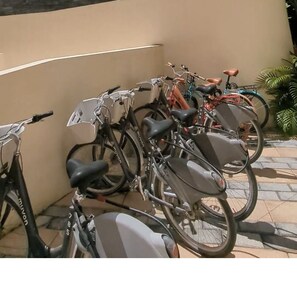 A row of bicycles parked against a wall.