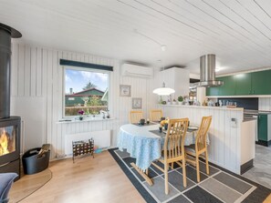 Une cuisine chaleureuse avec un coin repas, une cuisinière intégrée et une vue sur l’extérieur.