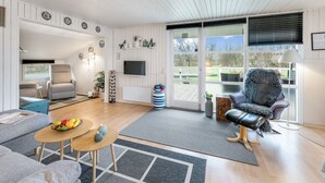 A modern living room with a sofa, armchair, and a dining area with a table and chairs. - "Fritzie" - 600m to the fjord by Interhome (Hemmet)