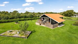 A modern house with a large deck, surrounded by well-maintained lawns and a vineyard. - "Fritzie" - 600m to the fjord by Interhome (Hemmet)