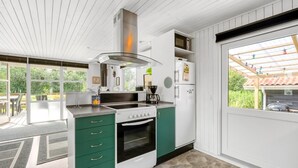 A modern kitchen with a stove, oven, and white cabinets. - "Fritzie" - 600m to the fjord by Interhome (Hemmet)