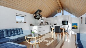 Un interior moderno con comedor, cocina y zona de estar.