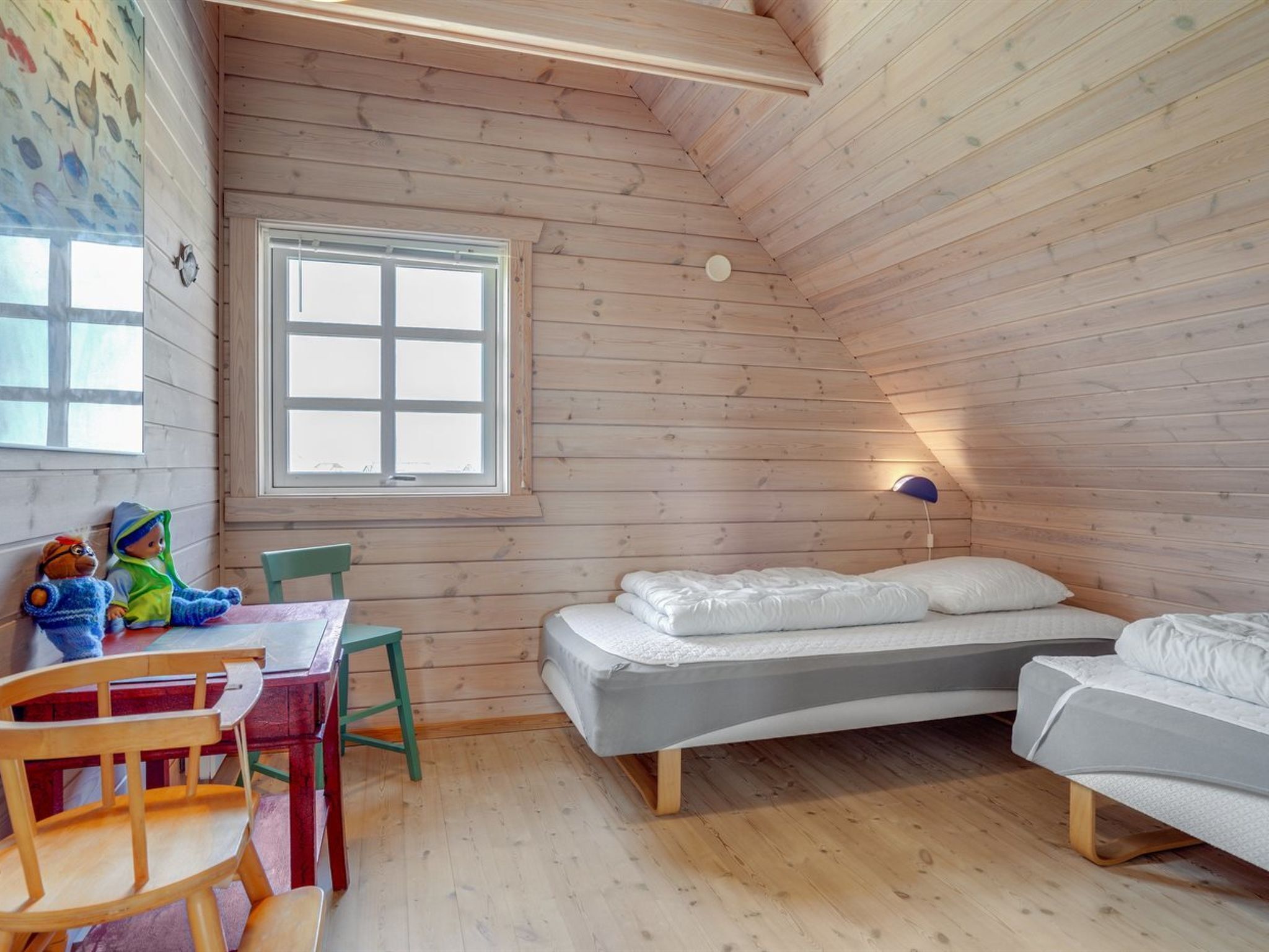Un chalet confortable avec une chambre à coucher aménagée en mezzanine, un coin repas et une fenêtre offrant une vue agréable.