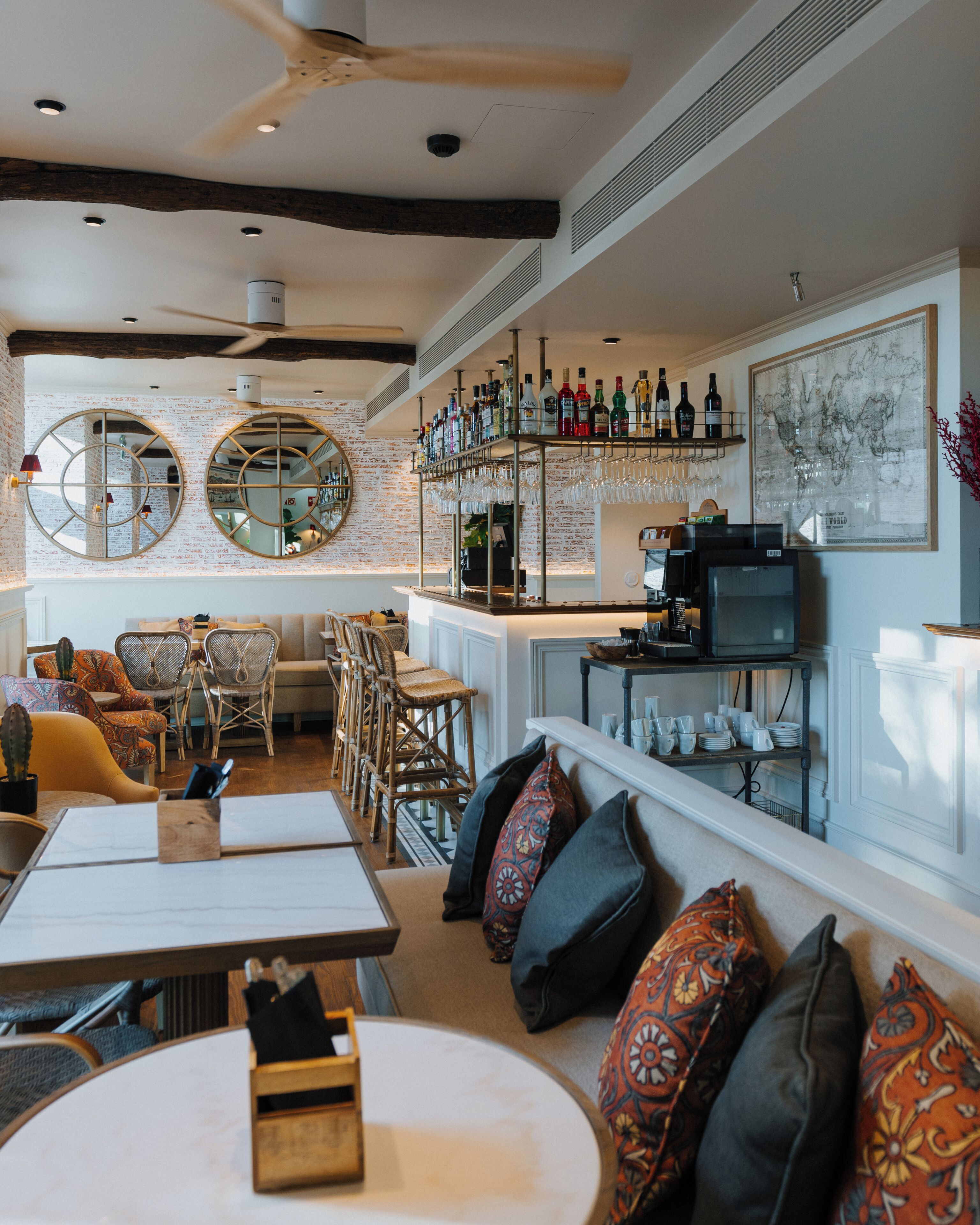 Un espace bar avec un assortiment de bouteilles d’alcool, un téléviseur et une grande œuvre d’art encadrée accrochée au mur.