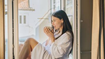 Una persona sentada junto a una ventana con vistas a edificios.