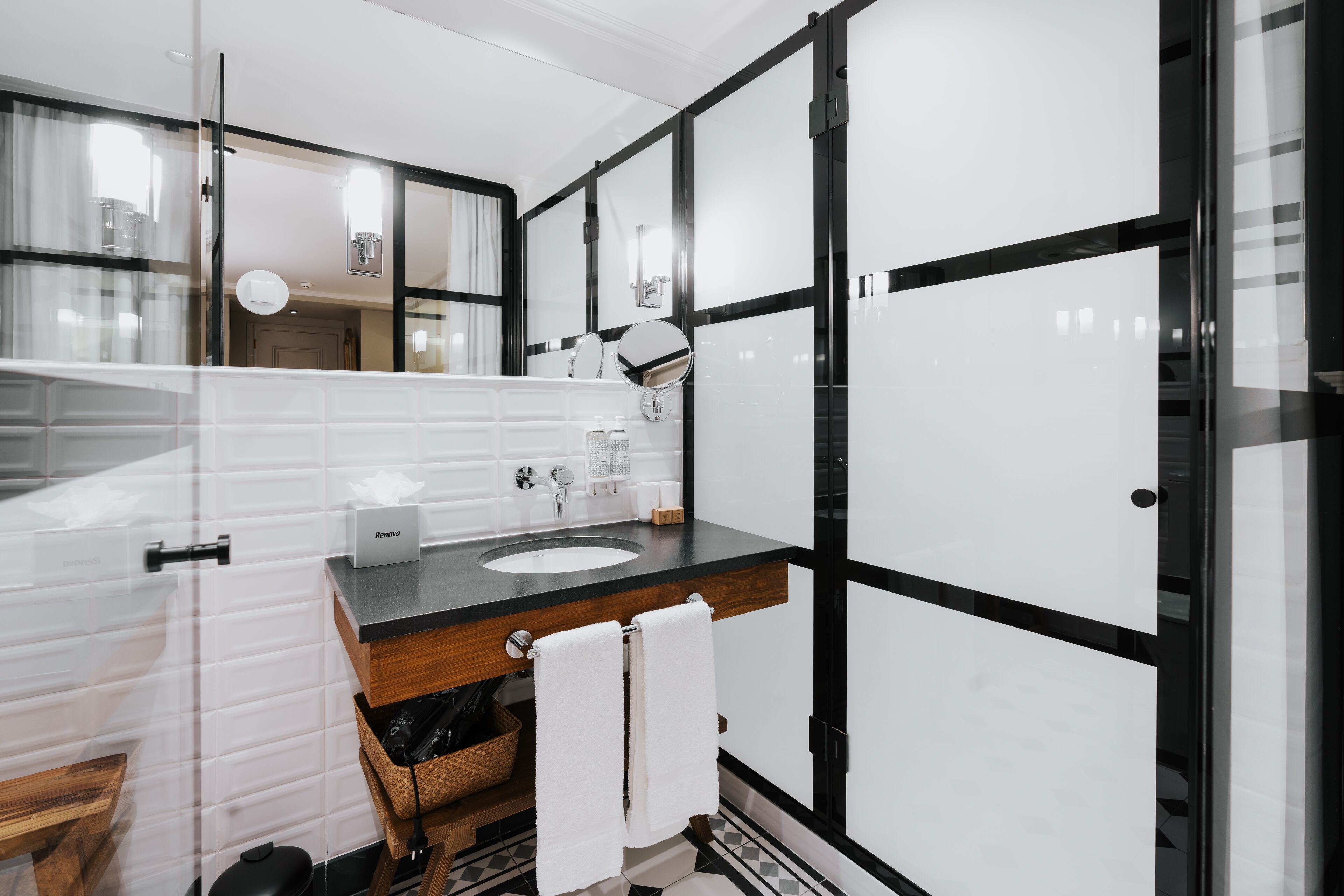 Un bany modern amb un mirall gran, un lavabo i un taulell.