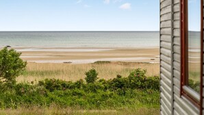 A coastal view from a house with a window overlooking a beach and ocean. - "Elpida" - 100m from the sea by Interhome (Glesborg)