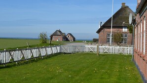 A rural setting with a brick building, a thatched-roof house, and a white fence. - "Adine" - 13km from the sea by Interhome (Bredebro)