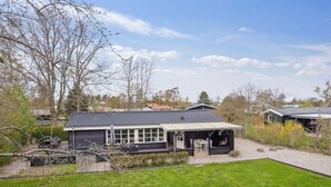 A modern house with a covered patio, a well-maintained lawn, and a clear sky. - "Mahalia" - 300m from the sea by Interhome (Sydals)