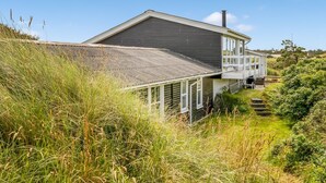 A two-story house with a sloped roof, a chimney, and a balcony. - "Stina" - 250m from the sea by Interhome (Løkken)