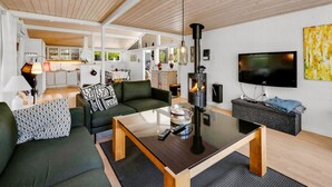 Un salon moderne avec un canapé, une table basse et un téléviseur.