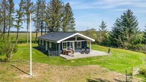 A single-story house with a covered patio, surrounded by a grassy yard and trees. - "Nanja" - 759m from the sea by Interhome (Løkken)