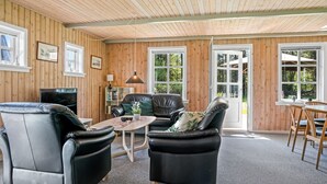 A cozy room with wooden walls and ceiling, featuring two leather sofas, a small table, and a TV. - "Nanja" - 759m from the sea by Interhome (Løkken)