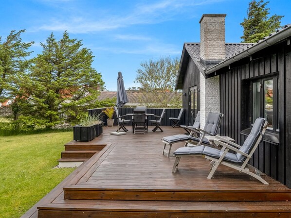 A deck with outdoor furniture, a table, and chairs.