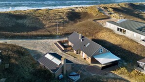 Il s’agit d’une propriété située sur la côte, comprenant plusieurs bâtiments, notamment une maison principale dotée d’un toit en pente et un garage séparé.