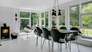 A modern dining area with a round table, black chairs, and a fireplace. - "Sighwith" - 500m from the sea by Interhome (Hals)