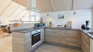 Una cucina moderna con un'isola grande, forno integrato e mobili in legno.