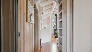 Un couloir en bois avec un plafond haut et une cheminée.