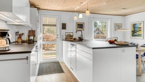 A modern kitchen with white cabinetry, a wooden ceiling, and pendant lighting. - "Milan" - 250m to the fjord by Interhome (Thyholm)