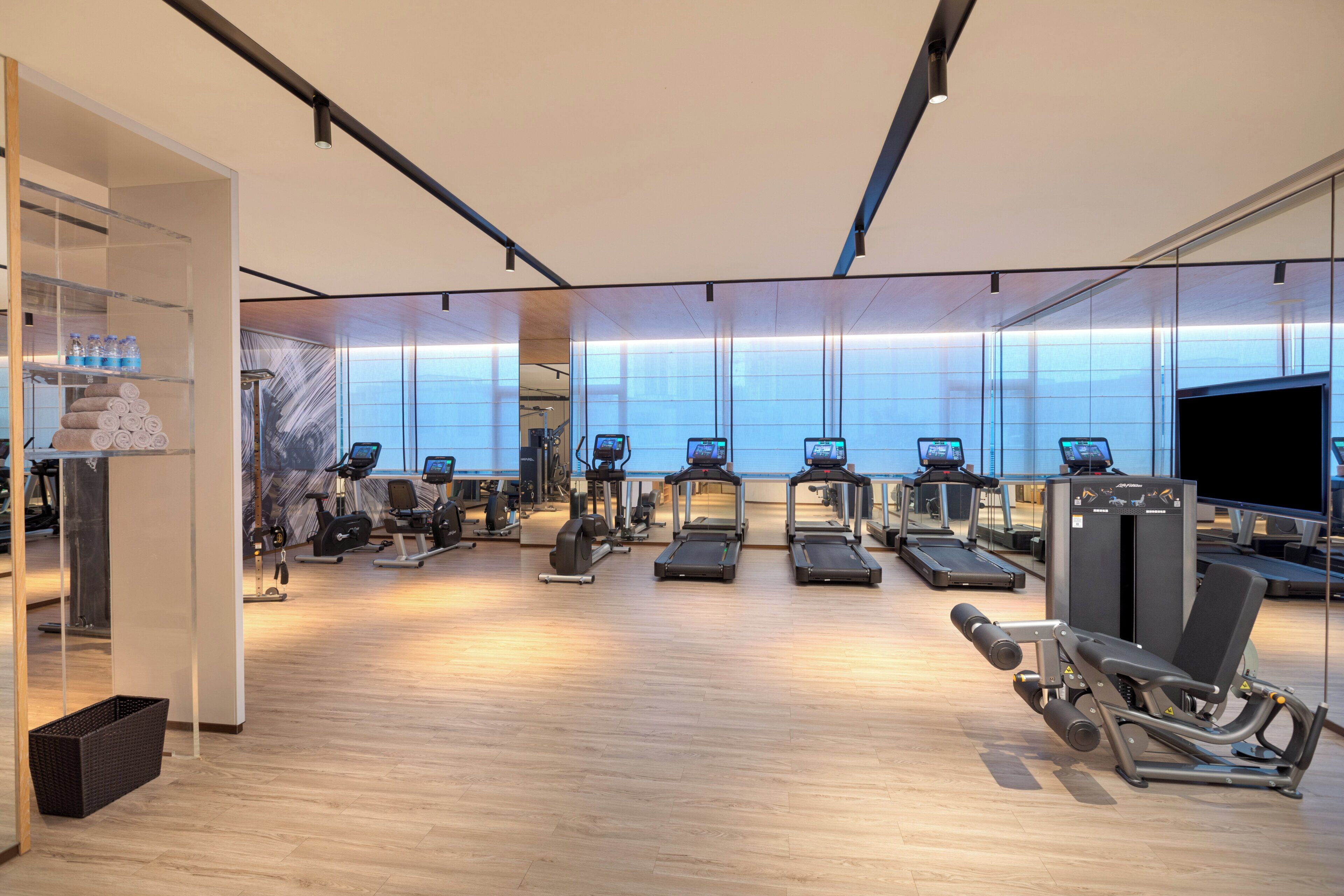 A gym with treadmills, elliptical machines, and weight equipment.
