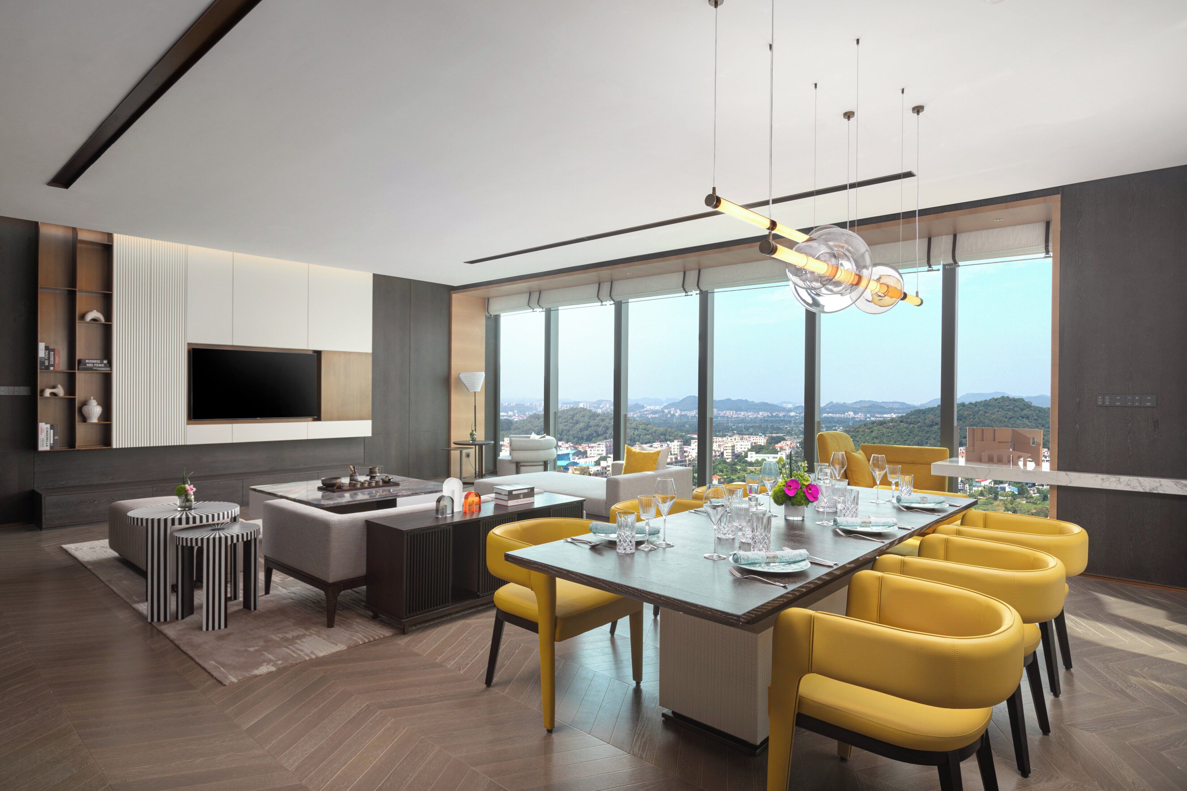 Un salon moderne avec un coin repas, de grandes fenêtres et une vue sur la ville.