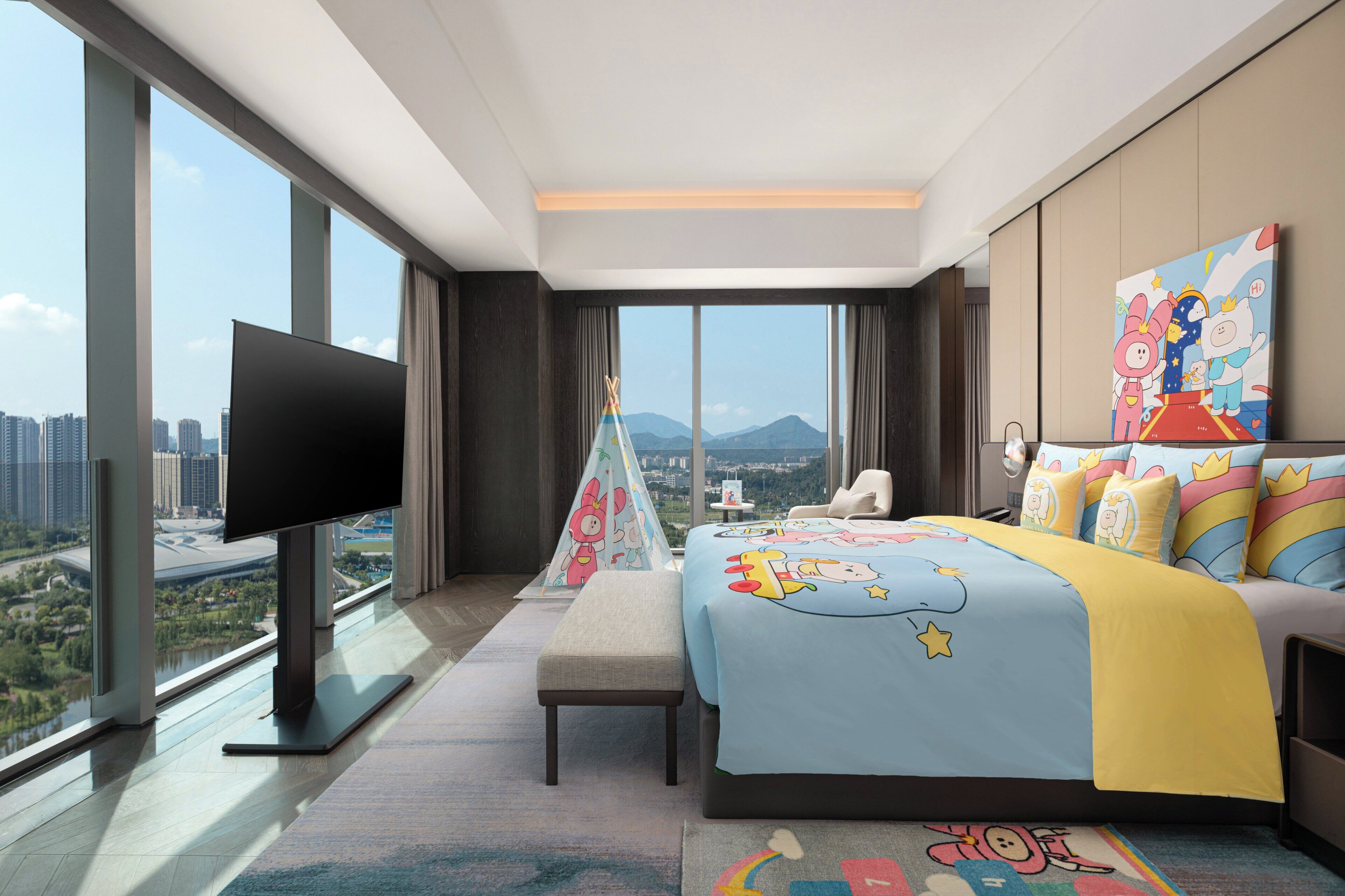Une chambre d’hôtel moderne dotée d’un grand lit, d’un téléviseur à écran plat, offrant une vue sur la ville et donnant sur les montagnes.