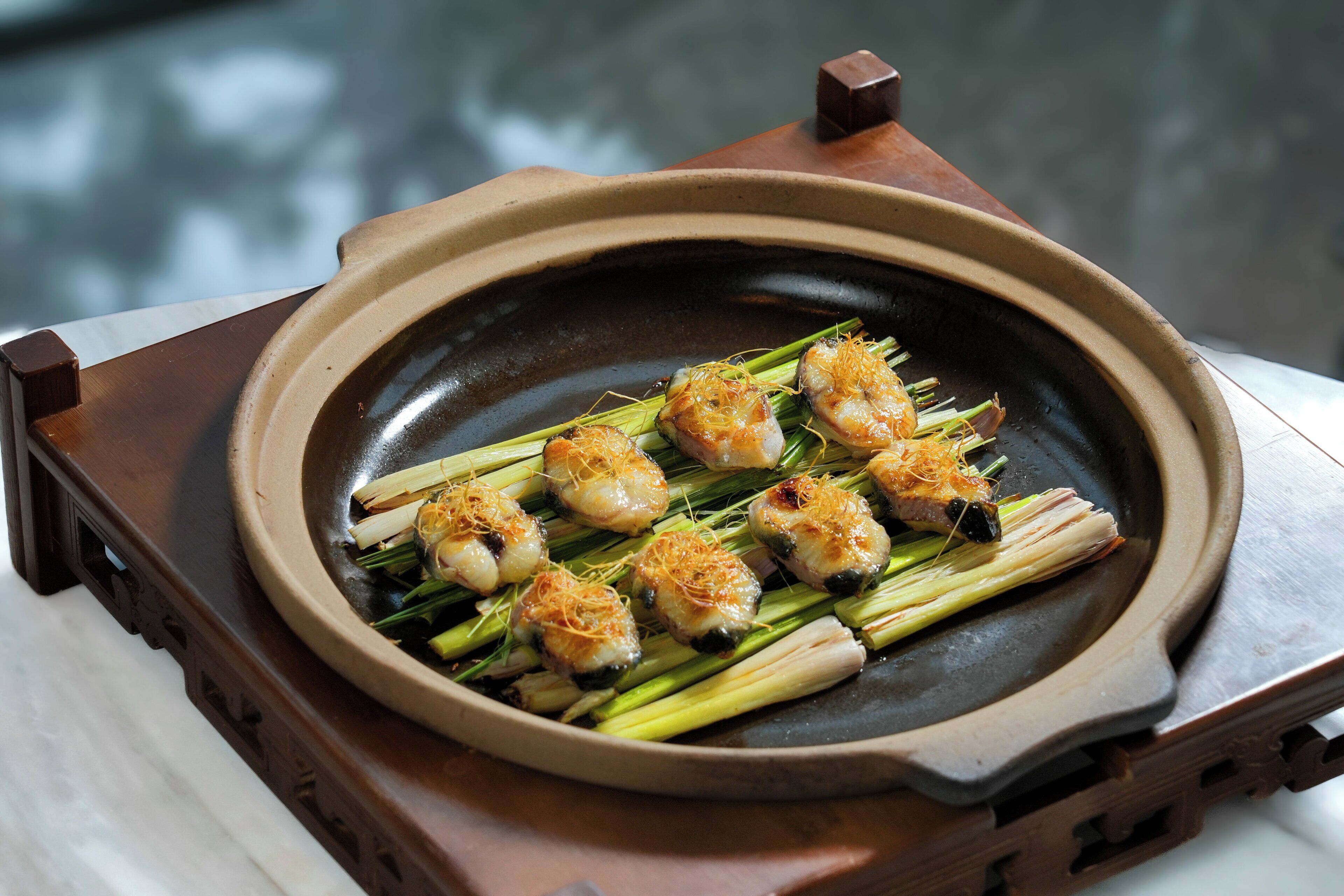 A dish of grilled shrimp on skewers with vegetables, served on a ceramic plate.