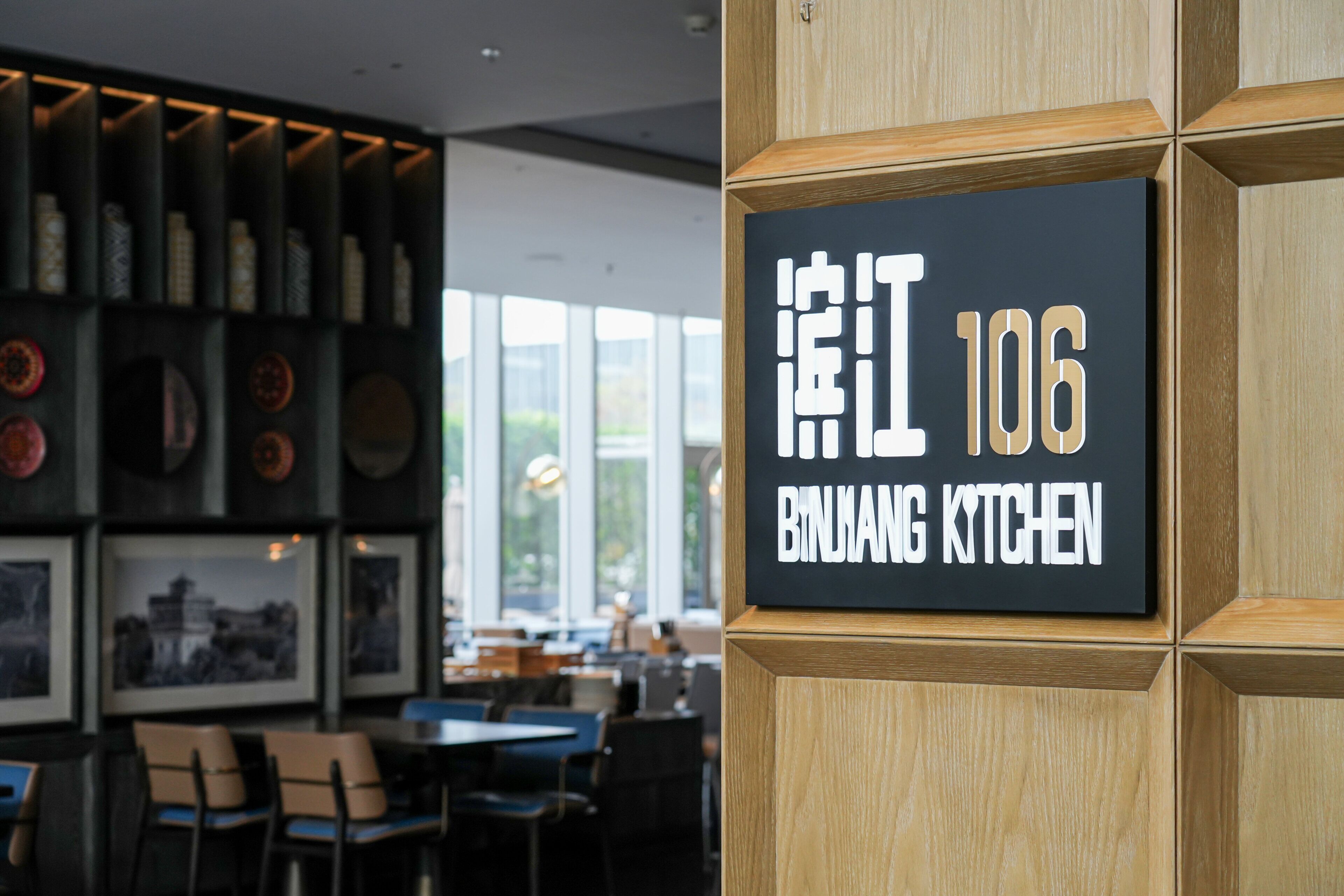 Ein Restaurantinneres mit einem Schild, auf dem 'BIRHANG KITCHEN' und die Zahl '106' stehen.