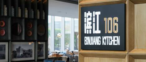 Ein Restaurantinneres mit einem Schild, auf dem 'BIRHANG KITCHEN' und die Zahl '106' stehen.