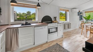 A modern kitchen with white cabinetry, a wooden countertop, and a large window. - "Valdemar" - 350m to the fjord by Interhome (Tarm)